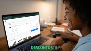 Mulher sorridente usa notebook em ambiente acessando o site do Carrefour. Na tela, aparece o carrinho de compras com uma Smart TV Samsung de 65 polegadas e o valor total da compra. Em destaque, é possível ver a área para adicionar cupom de desconto e a opção de finalizar a compra. Na parte inferior da imagem, aparece o logo do site Descontos Top.