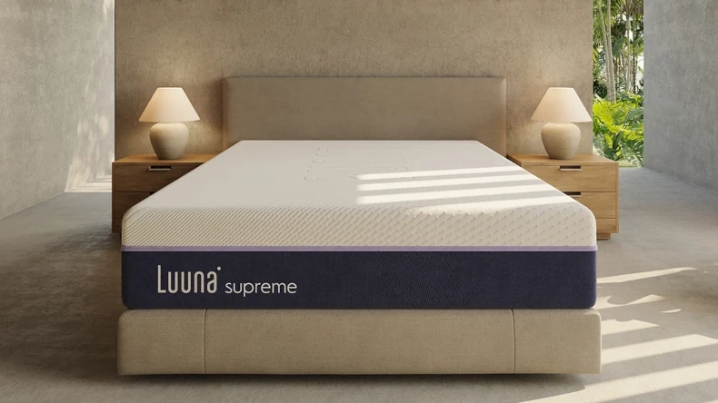 Colchão do modelo Luuna Supreme em um quarto de cor bege com dois criados mudos e dois abajures.