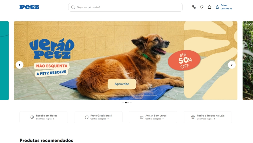 Imagem da página inicial do site Petz, destacando uma promoção de até 50% de desconto, com um cachorro deitado em um tapete azul e fundo amarelo, promovendo compras online.